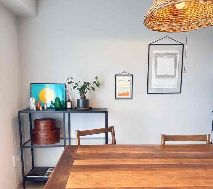 Warm brown wood tone dining room featuring a dining table, chairs, black shelf, and plant creating a modern natural atmosphere