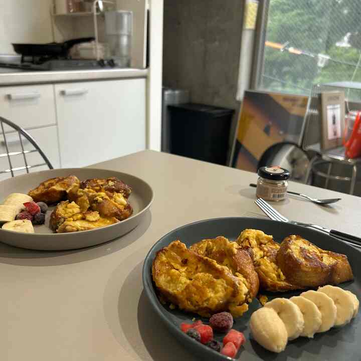 White and gray toned kitchen featuring a dining table with simple breakfast dishes and silver stools in a cozy space