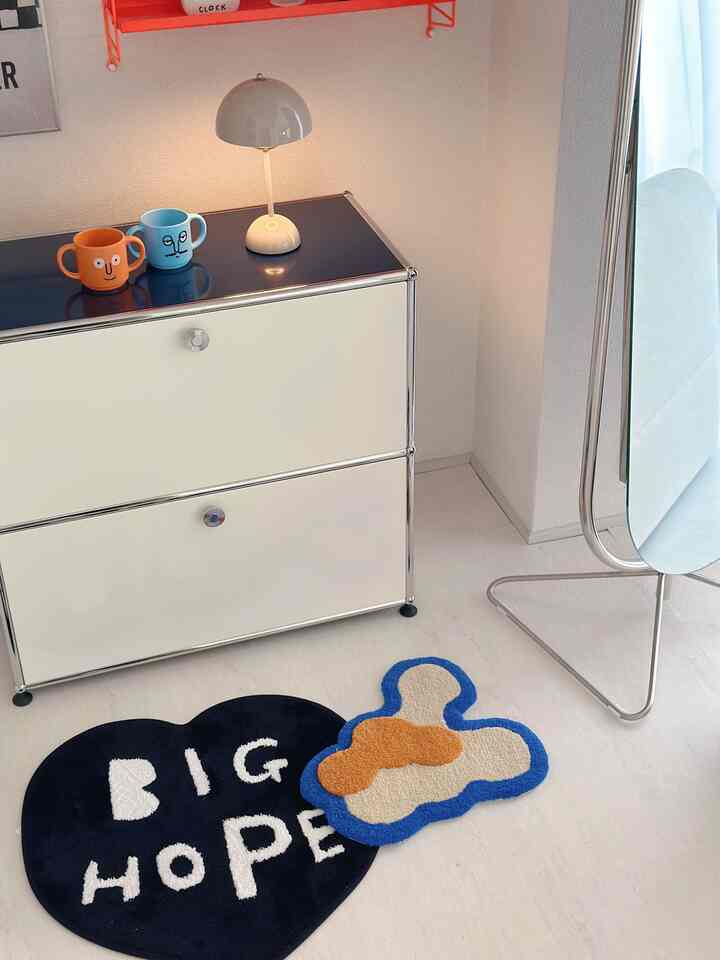 Modern living room featuring silver and white sideboard, blue and orange small rugs, with bright and clean atmosphere