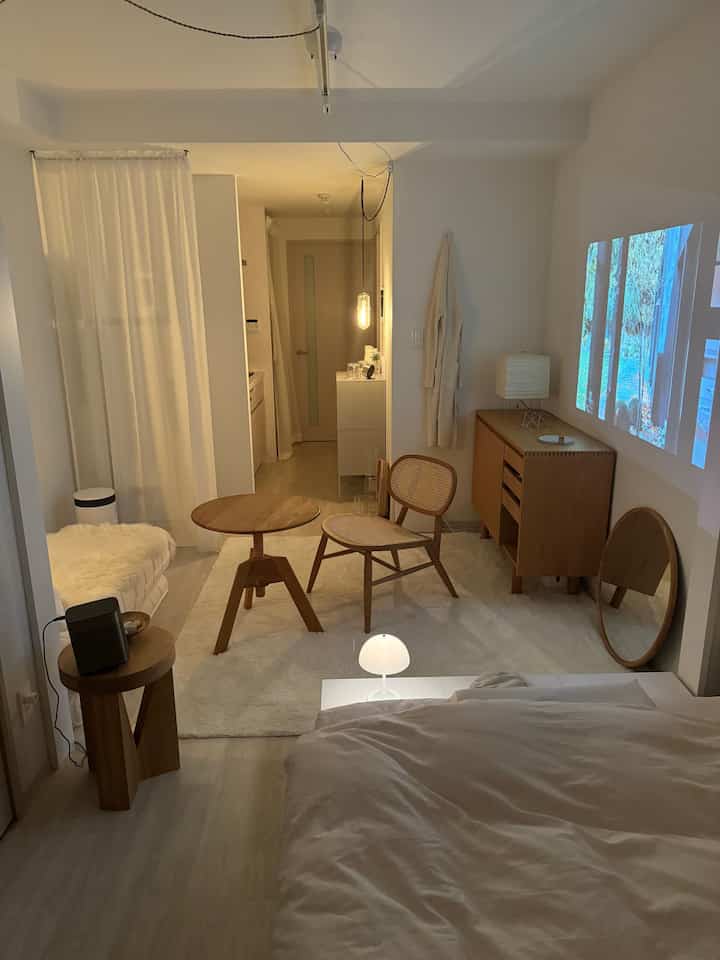 Cozy bedroom with warm wood tone furniture and white accents featuring a projector beam on the wall at night