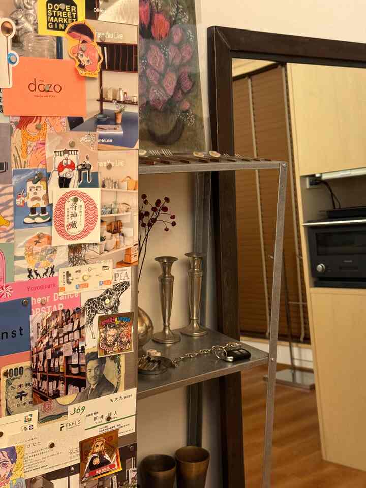 Compact kitchen space featuring a silver metal shelf and various wall decorations