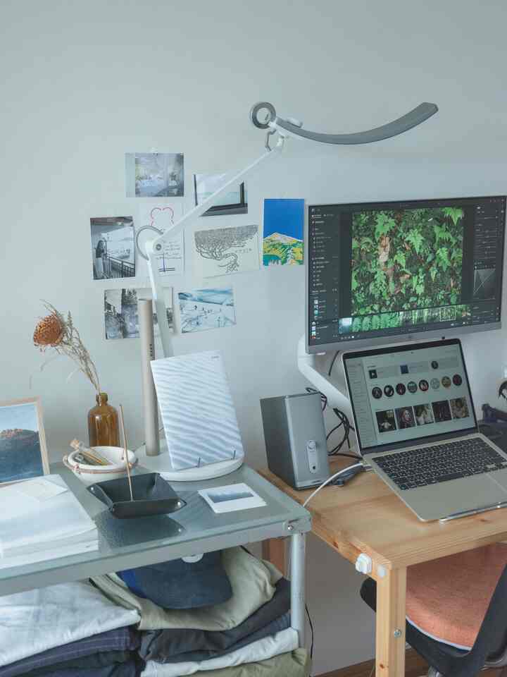 白とウッドトーンの調和した一人暮らし用ホームオフィス、机とモニターが整然と配置されたコンパクトな部屋