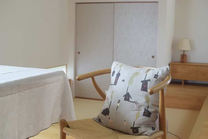 Natural toned dining room featuring Y Chair with sauna pattern cushion and a linen tablecloth, creating a clean and warm atmosphere