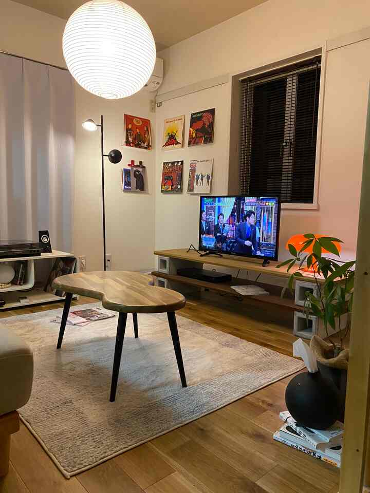 ウッドトーンと白を基調としたミッドセンチュリーモダンのリビング、レトロな小物と個性的なコーヒーテーブルが配置された印象的な空間