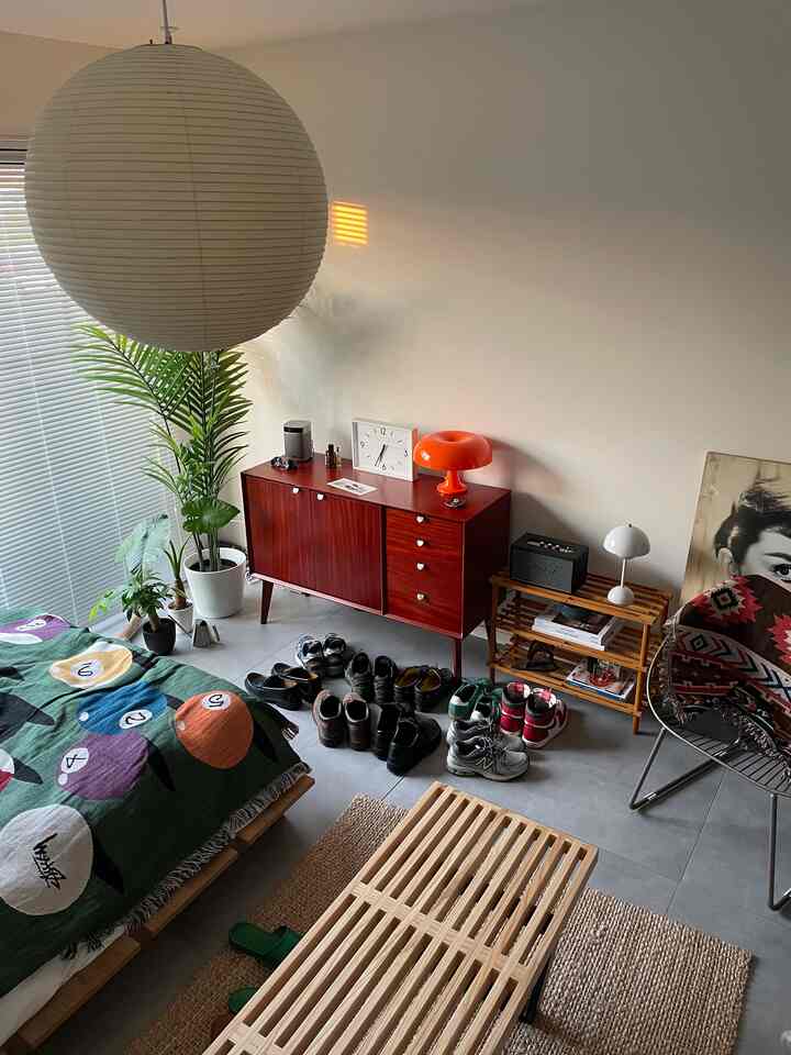 自然な色調の小さな部屋、様々な靴が整然と収納された北欧スタイルの家具とシンプルなインテリア