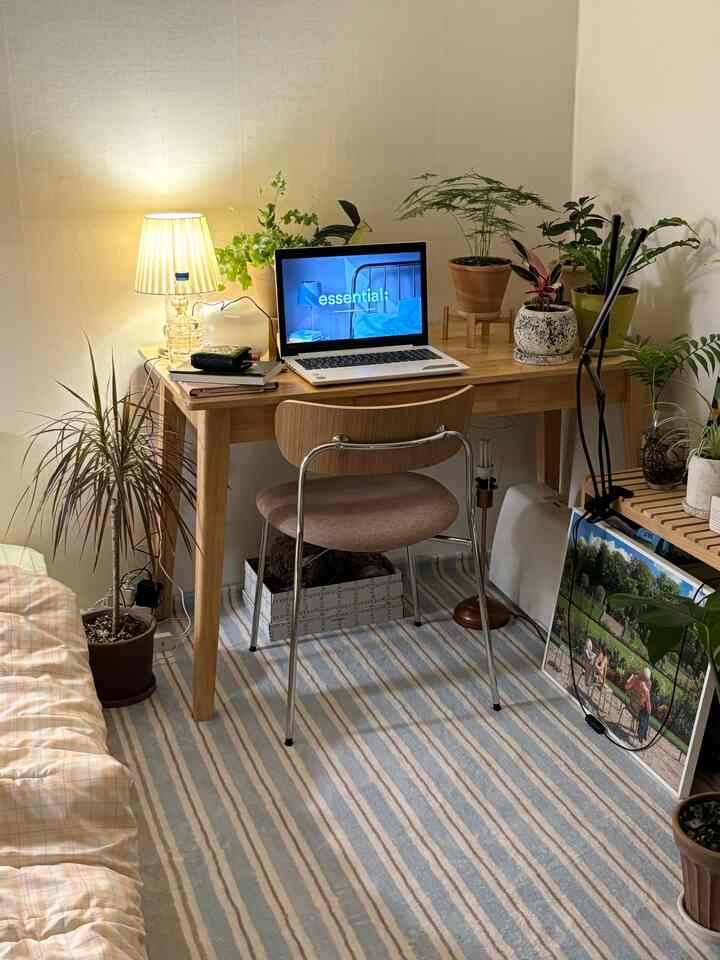 柔らかなナチュラルトーンのホームオフィス空間、木製デスクと複数の植物が配置された温かみあるインテリア