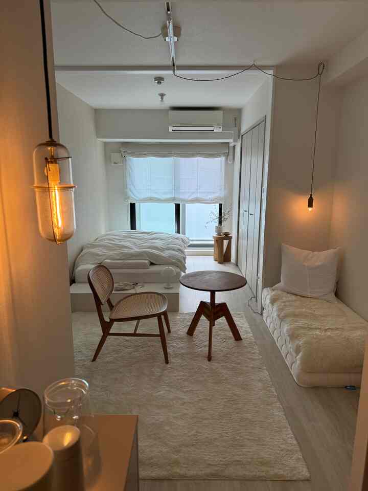 White and beige tone small single household room featuring wood furniture and lighting with a natural atmosphere