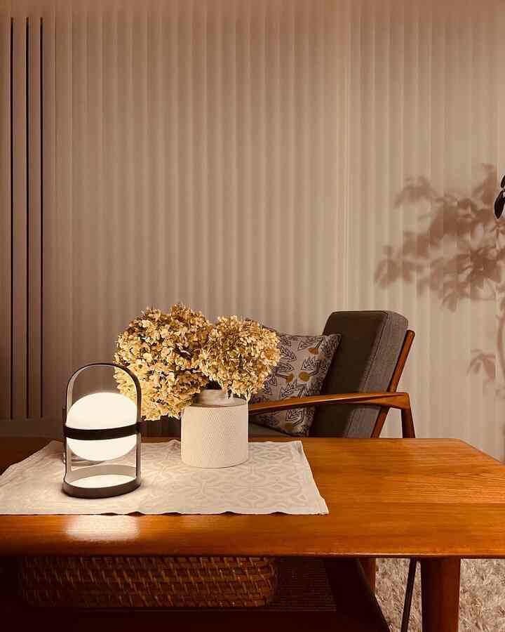 温かみのあるウッドトーンのリビング、コーヒーテーブルにドライフラワーと灯りを配置した雰囲気あるインテリア