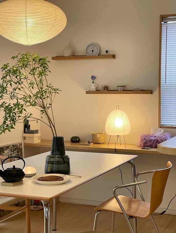 柔らかなナチュラル色調のリビング、木製家具と植物、有名なイサム・ノグチの照明が温かみのある雰囲気を演出