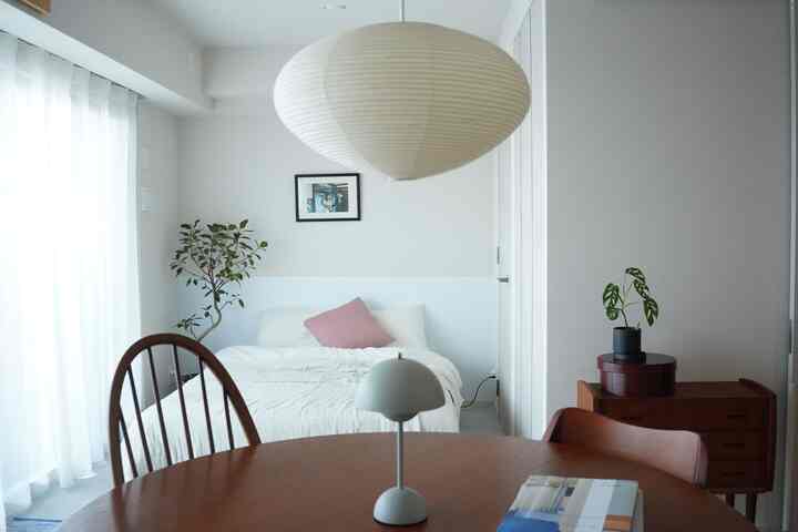 白と木目調が調和した1LDKのダイニングと寝室が一体化したナチュラルモダンな空間