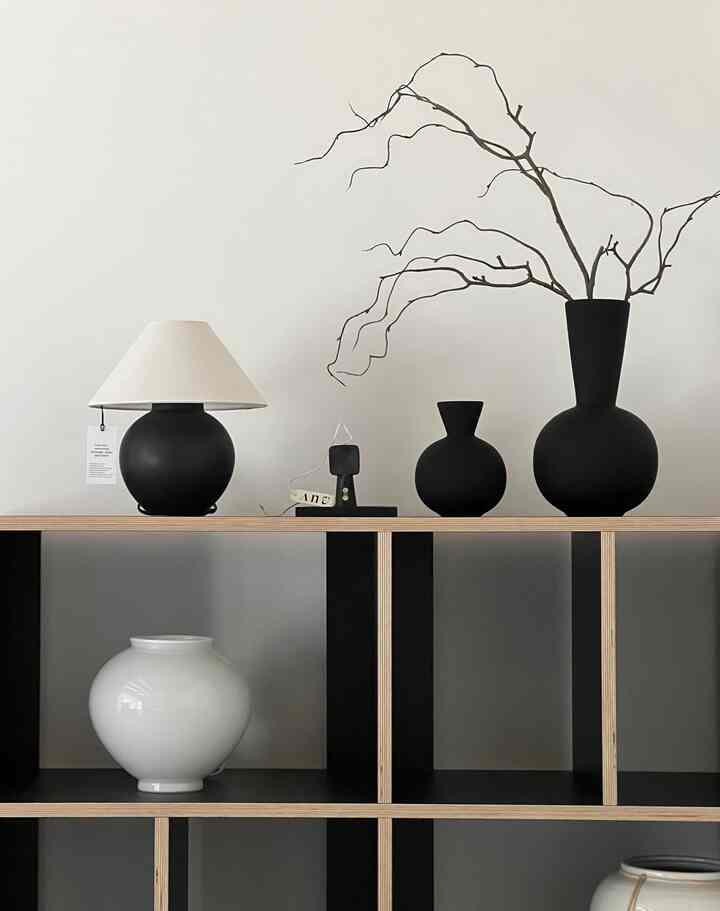 黒と白のトーンのモジュラー家具の棚にモダンでシンプルなオブジェが配置された空間