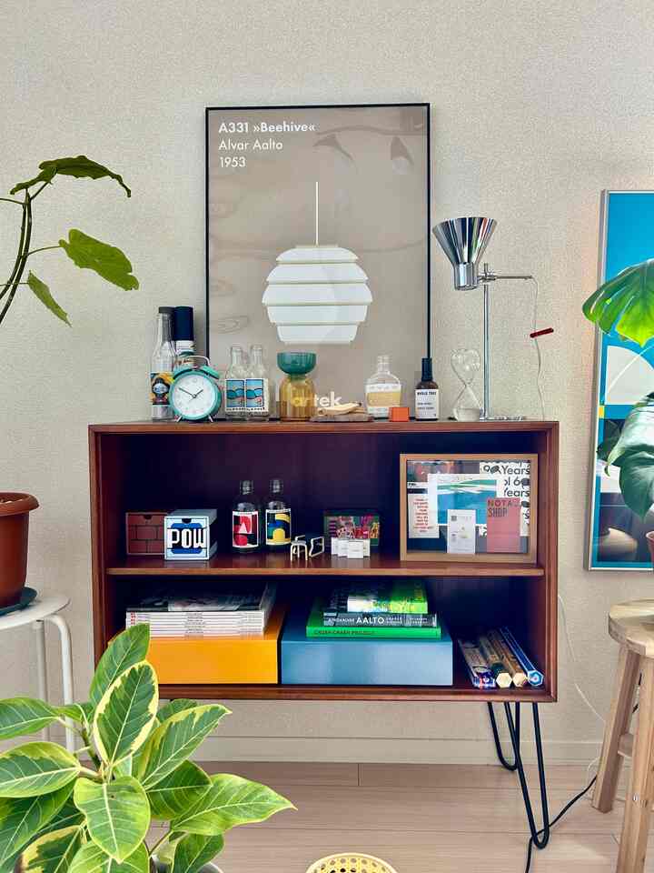 ブラウンのキャビネットと複数の植物が配置されたシンプルなヴィンテージスタイルの室内空間