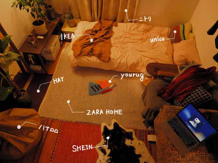 Warm beige and brown-toned studio apartment living room and bedroom featuring beige rugs, wooden bookshelf, and natural modern decor