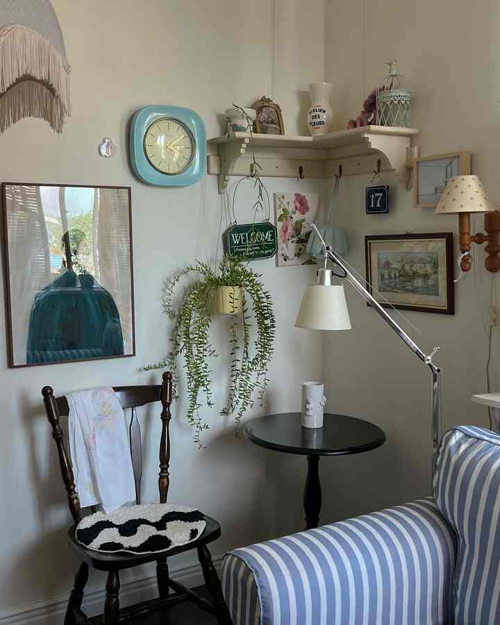 白い壁とビンテージ家具、青い壁時計が配置された居心地の良いカフェ風リビング