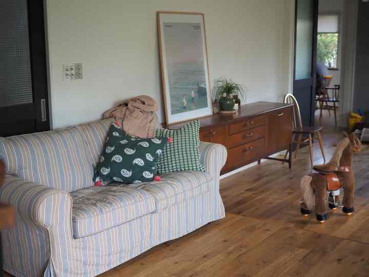 Natural-toned living room with brown wood flooring and striped sofa creating a cozy atmosphere