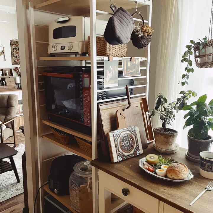 ナチュラルな色調のキッチン、収納棚とダイニングテーブルが配置された温かみのある雰囲気のインテリア