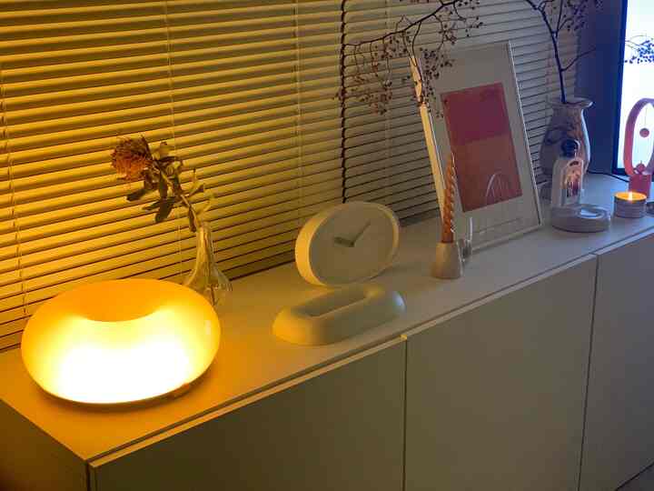 Warm beige tone living room featuring white cabinet with ambient lighting and simple décor