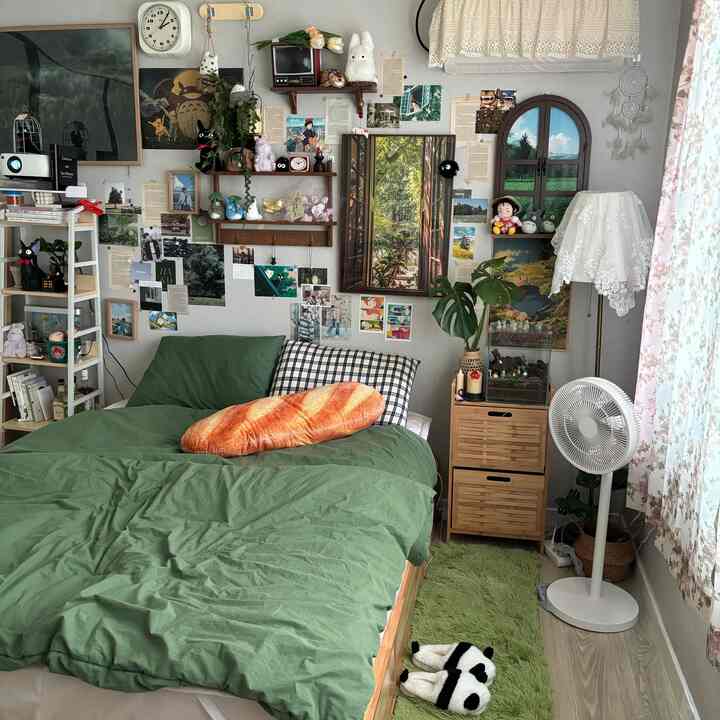 ナチュラルカラーの寝室、ジブリのキャラクターと緑の寝具が配置された雰囲気のあるインテリア