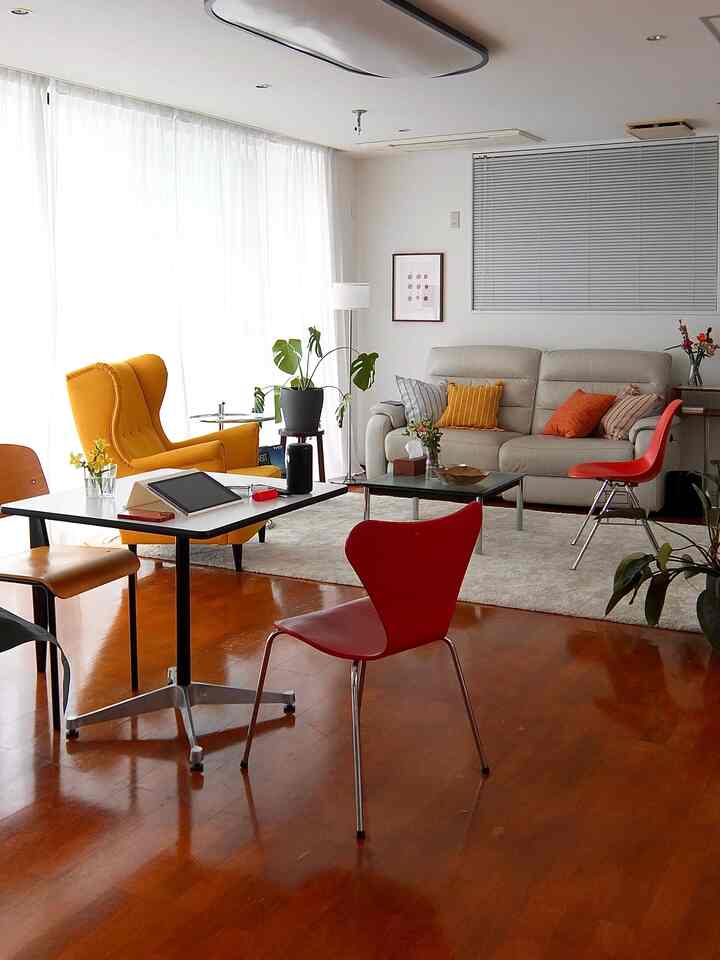 Bright natural-toned living and dining space featuring sofa, armchair, and dining chairs with a modern minimalist atmosphere