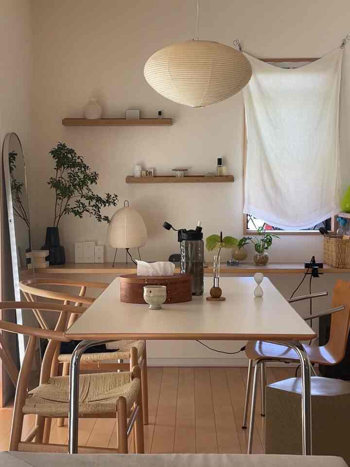 白とベージュの色調のダイニングルーム、木製の椅子とテーブルが配置された自然で落ち着いた雰囲気のあるインテリア