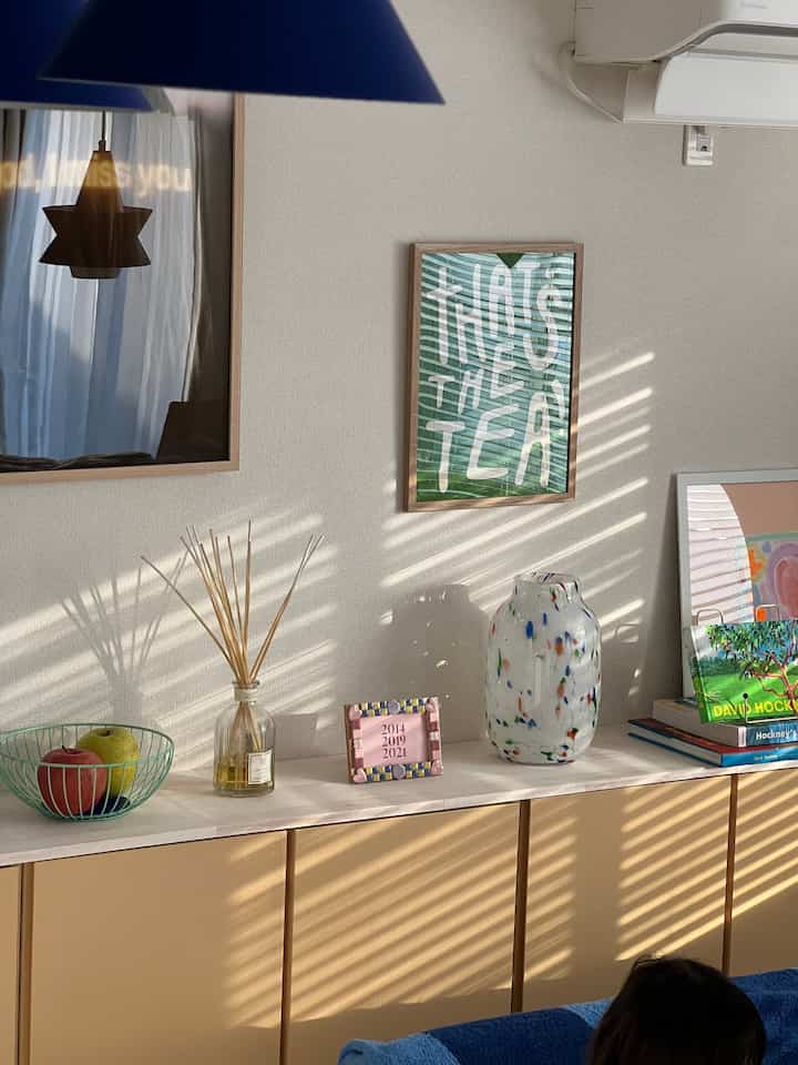 Beige-toned storage cabinet in dining room wall featuring decorative vases and picture frames with a natural ambiance