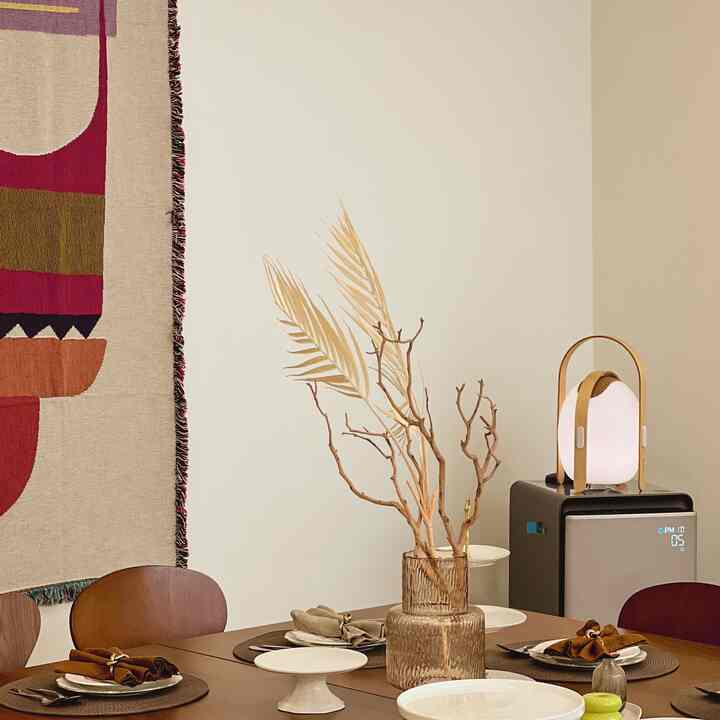 ブラウンのトーンが特徴のダイニングルーム、木製のダイニングテーブルとチェア、白い壁が配された温かみのある雰囲気のあるインテリア