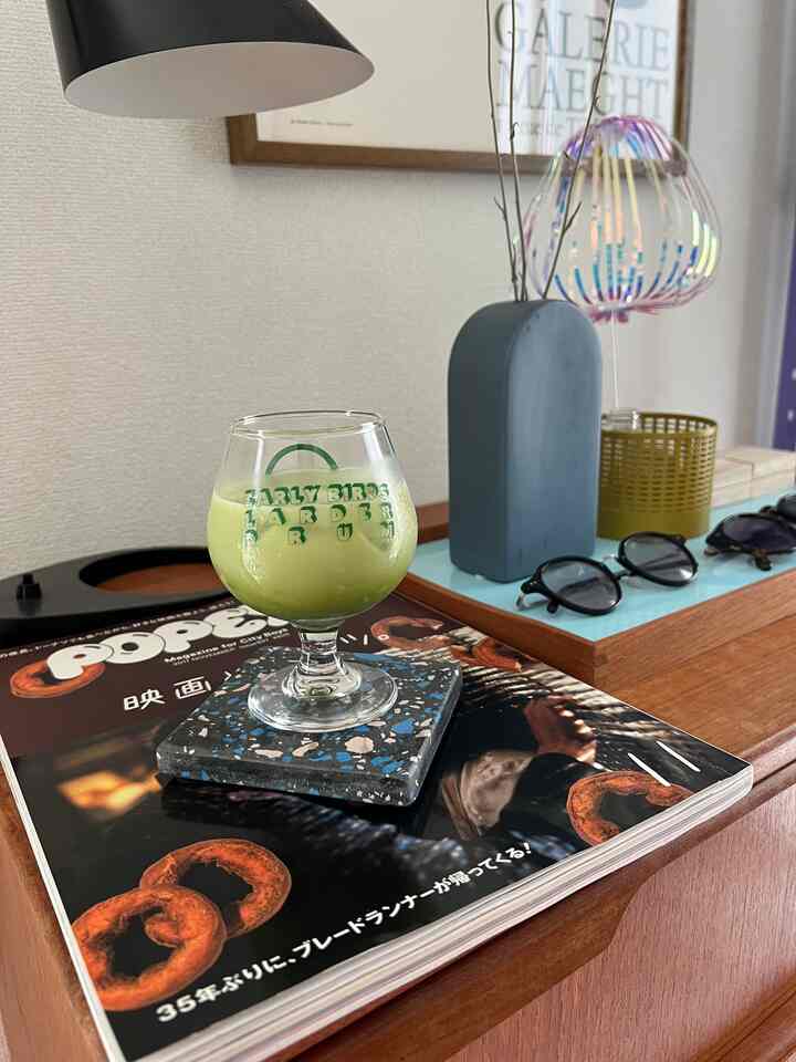 茶色の木目調が印象的なリビング、デンマークヴィンテージのチェストにフィンユールのトレイや花瓶、テーブルランプが配置された雰囲気のあるインテリア