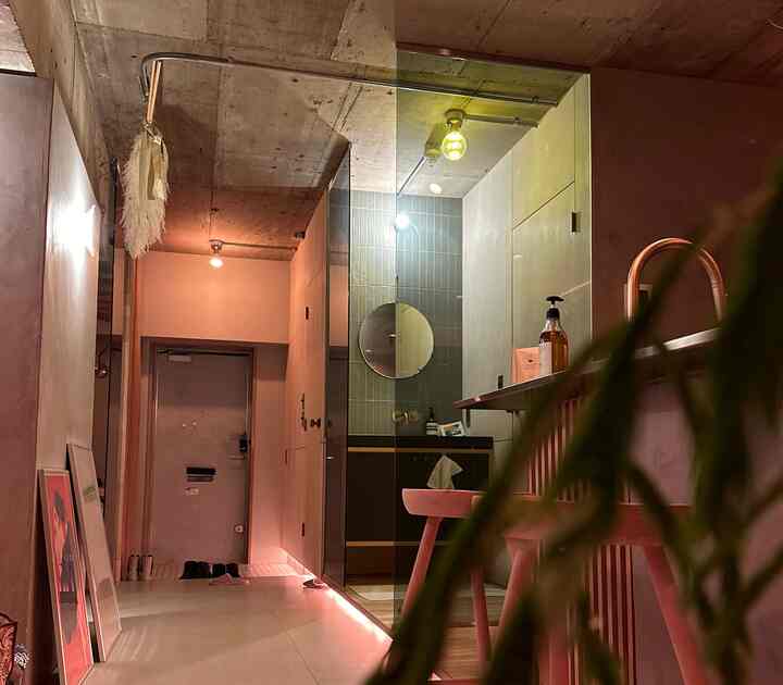 黄色い照明と木目調家具が調和した、浴室と玄関の見えるナチュラルモダンなインテリア空間