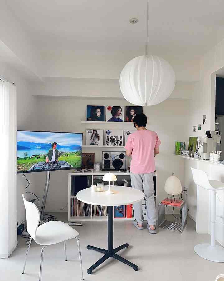 白を基調としたモダンなダイニングルーム、セブンチェアと丸テーブル、照明とオーディオ機器が配された印象的なインテリア。