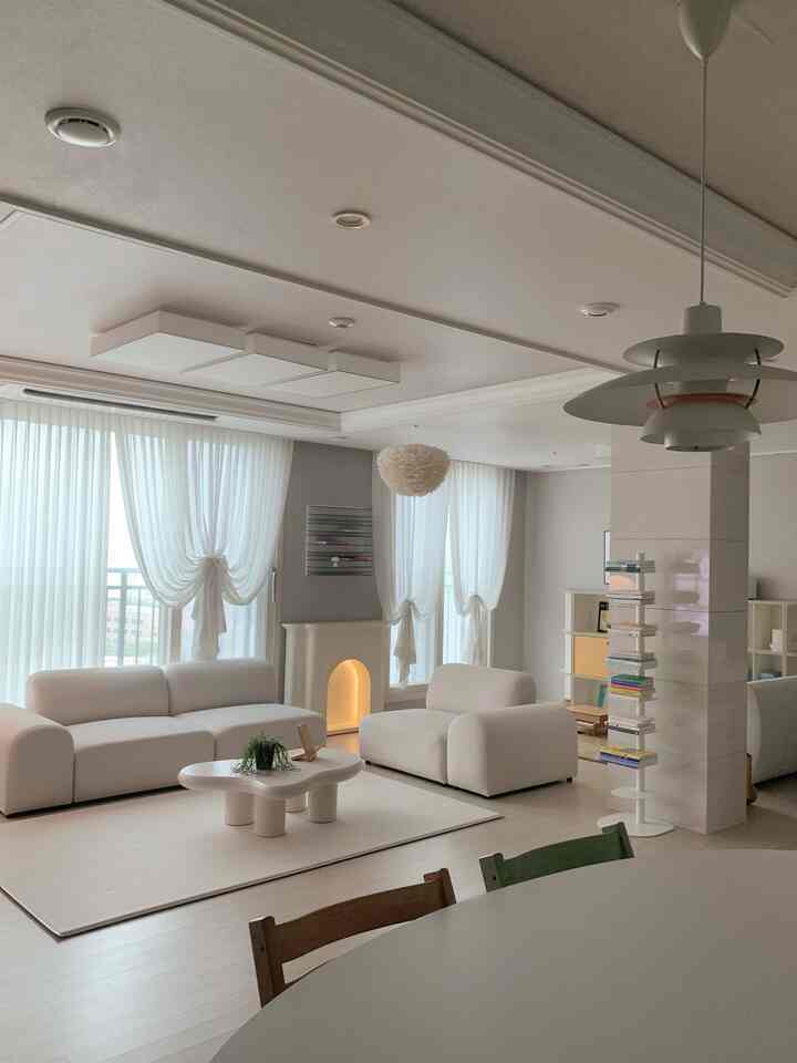 白を基調としたナチュラルモダンなリビングルーム、快適なソファと個性的なコーヒーテーブルが配置された明るく清潔感ある空間