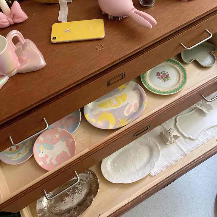 ナチュラルな木目調のドレッサーと色とりどりの皿が整頓された温かみのある収納スペース