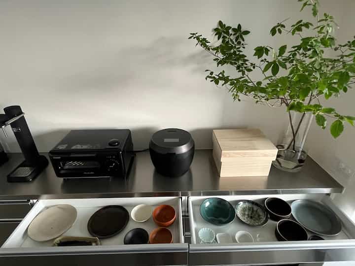 ナチュラルカラーのキッチン、和食器とキッチン家電が整然と配置された雰囲気のあるインテリア