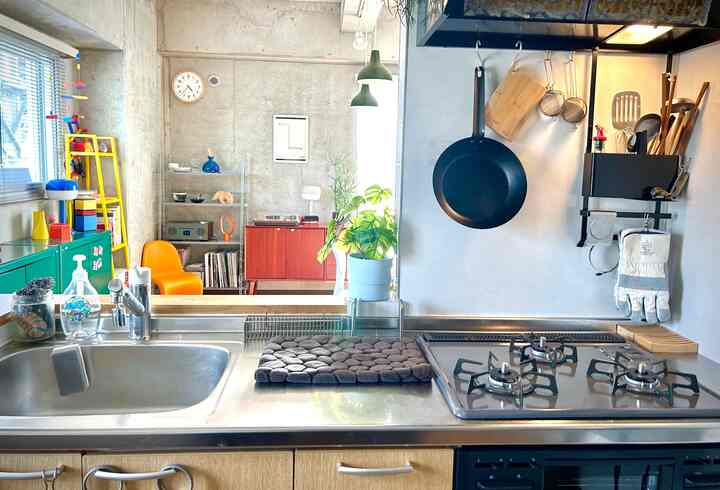 白とステンレス調のワンルームキッチン、清潔感のある調理台とモダンなキッチン用品が配置された雰囲気のあるインテリア