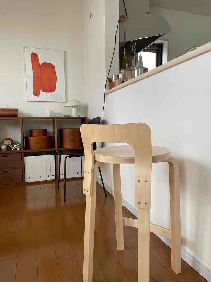 Wood-tone kitchen space featuring the Artek High Chair K65 stool with a simple and bright atmosphere