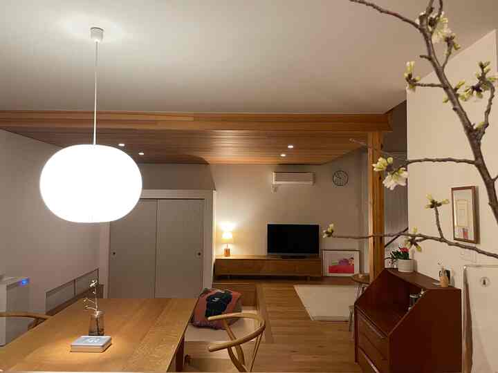 Warm wood tone and white-walled living and dining room featuring simple, natural Japandi style interior