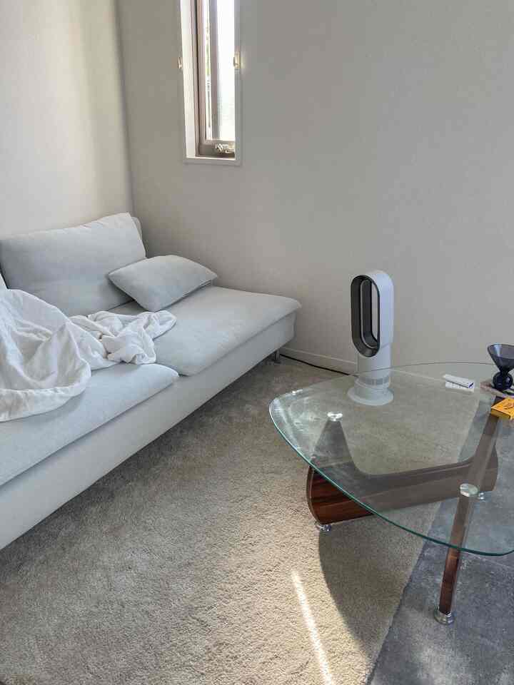 ホワイトとグレーのモノトーンの一人暮らしリビング、シンプルで自然光が差し込む雰囲気のあるインテリア