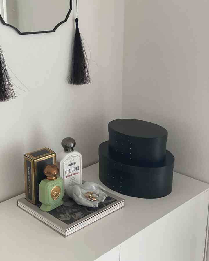 Modern corner cabinet in white tones featuring simple interior accessories on top with a clean and minimal atmosphere