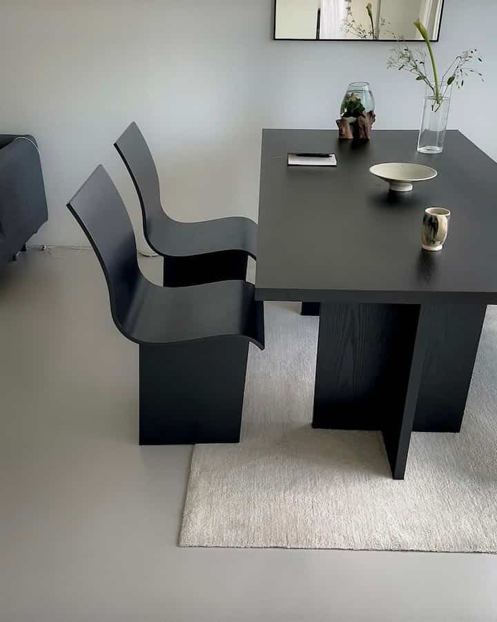 White and black toned dining room featuring a simple dining table and chairs in a modern setting