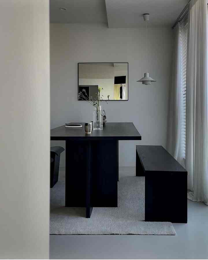 White and black tone dining room featuring a simple modern table and bench with a clean atmosphere