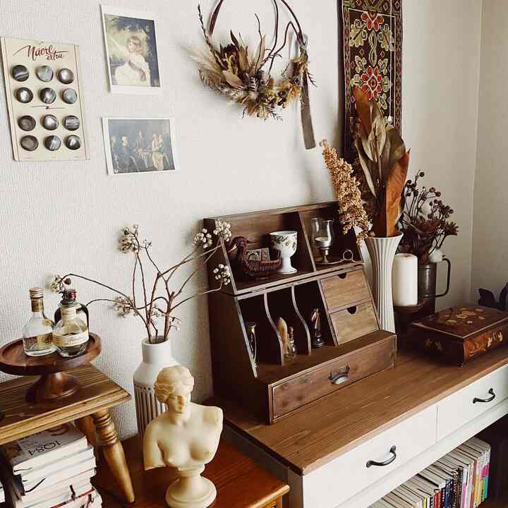 ブラウンの木目調ヴィンテージリビング、アンティークな花瓶や壁飾りが配置された雰囲気のあるインテリア