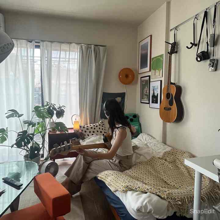 ナチュラルな色調の8畳寝室、窓辺に植物と間接照明が配置された温かみのあるインテリア