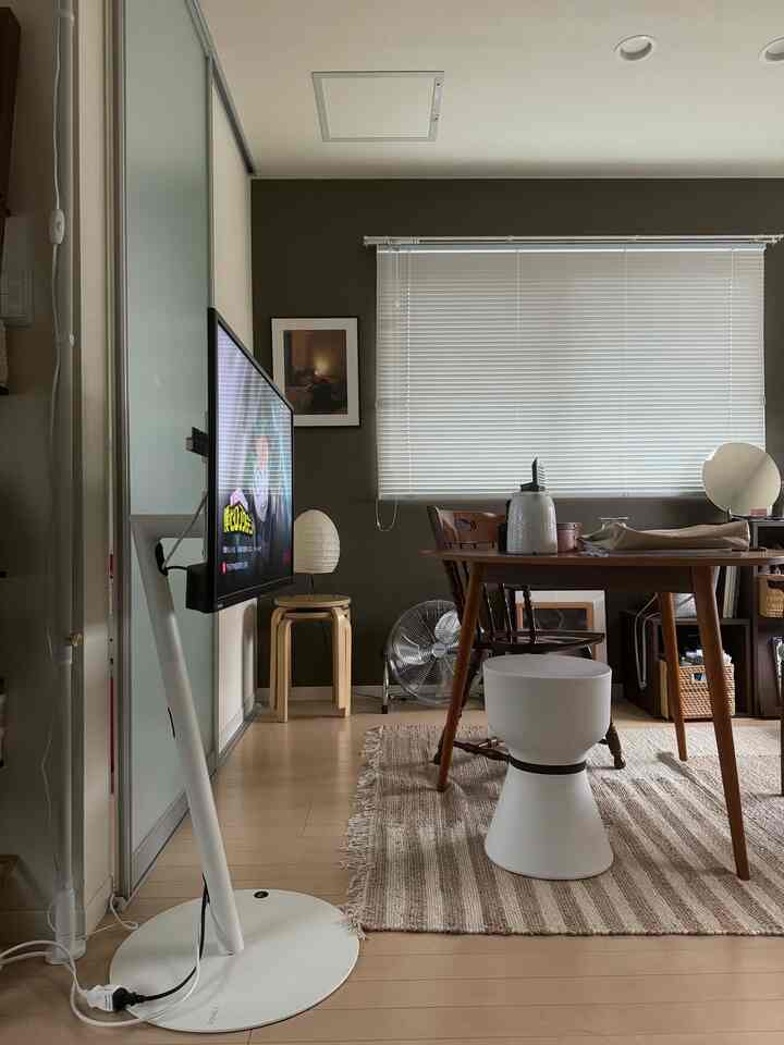Natural beige and wood tone dining room featuring white blinds and a TV stand, creating a cozy atmosphere