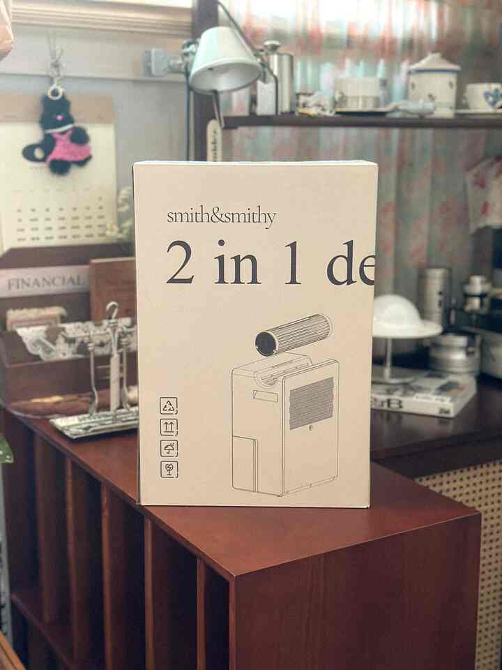 Cozy indoor space featuring warm wood tone cabinet with a double mini dehumidifier box on top, table lamp and floral curtain in the background