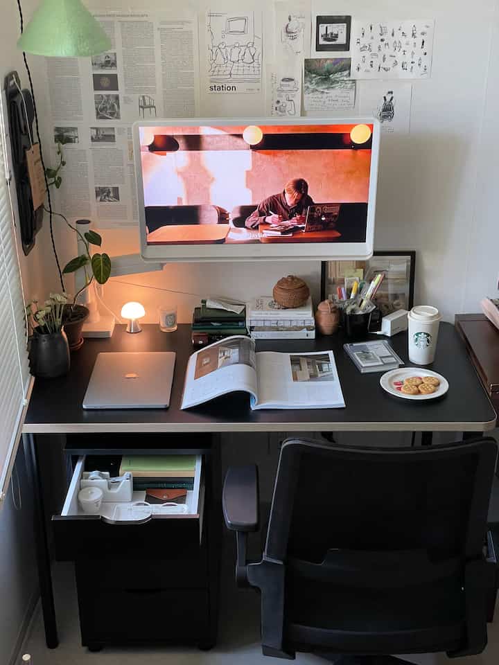 白い壁と黒いデスク、モニターとオフィスチェアが配置されたモダンなホームオフィスの印象的な空間