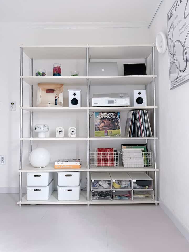 白色調のリビング本棚、多目的収納ボックスとインテリア小物がきれいに整理された空間