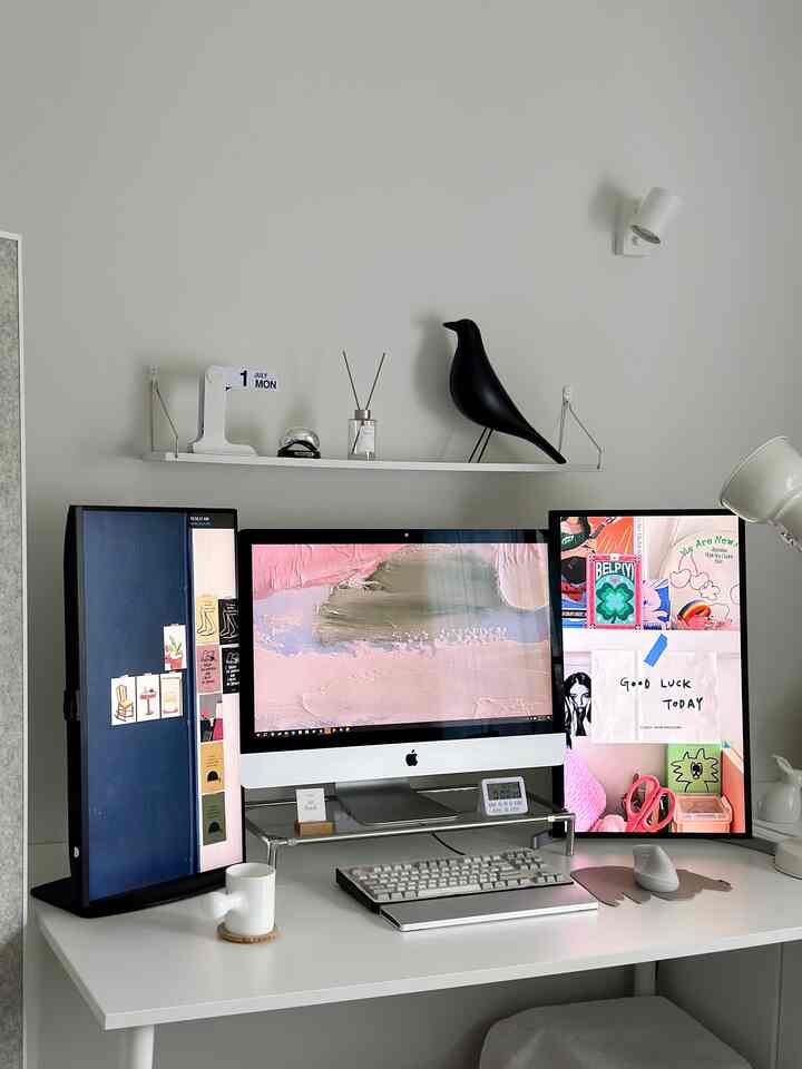 White-toned home office featuring a clean desk with dual monitors in a modern workspace