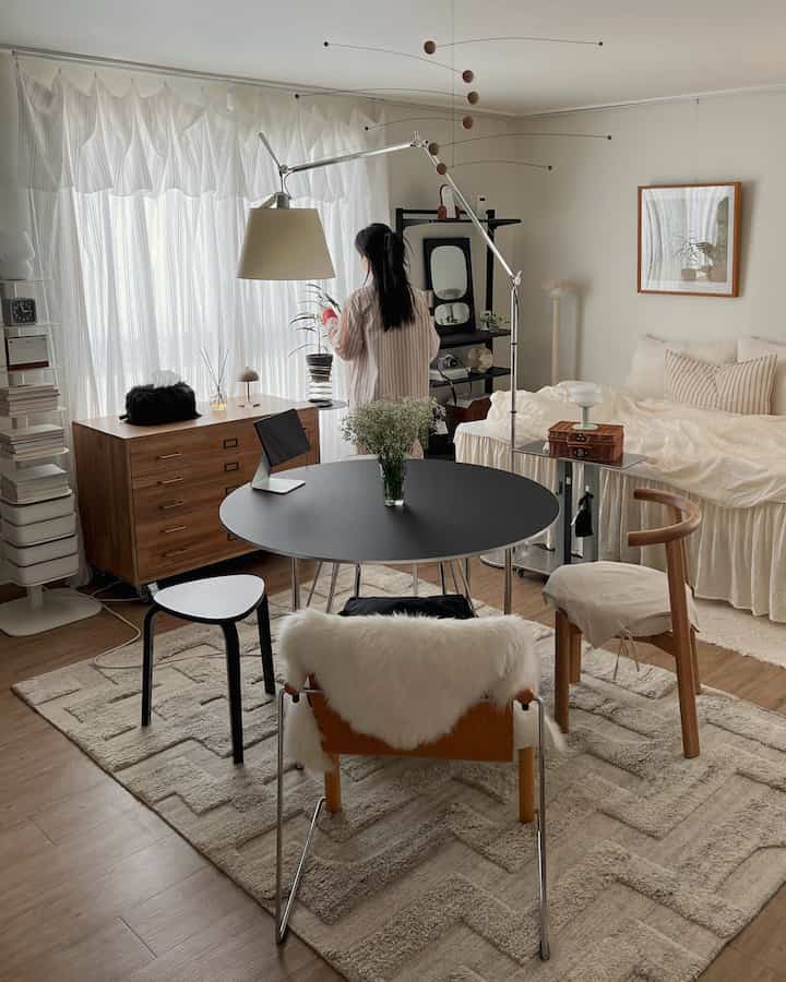 ナチュラルな木目調とブラックのテーブルが調和する8坪ワンルームの寝室、温かみのある雰囲気のインテリア