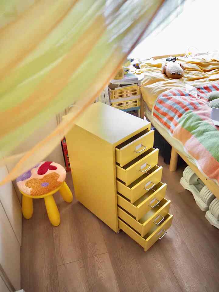 Yellow-toned bedroom featuring a HELMER chest of drawers and a children's stool with a cozy atmosphere