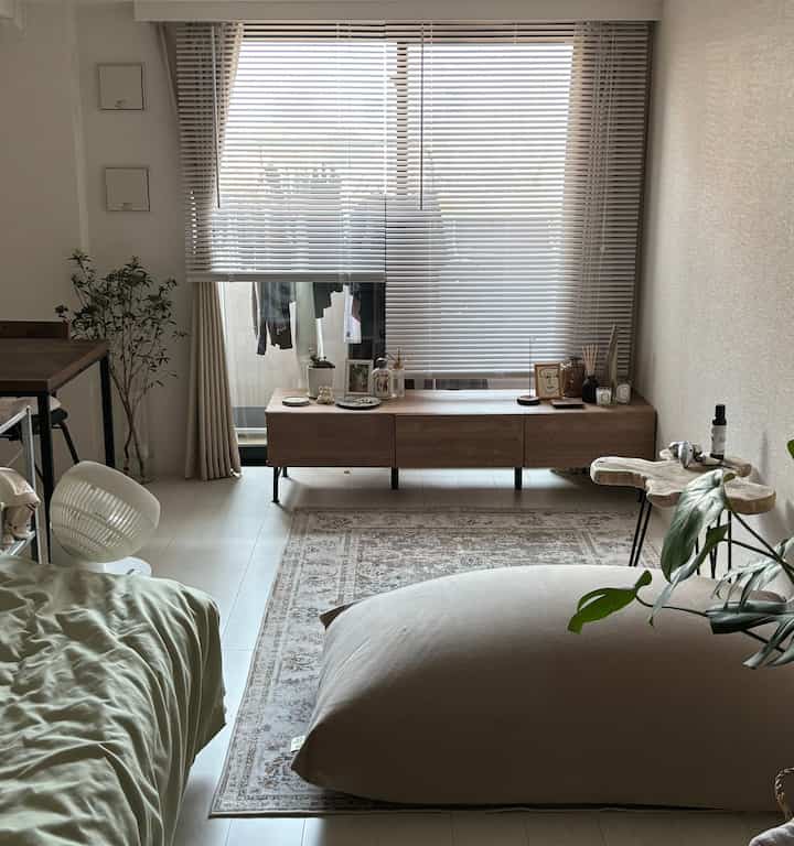 White and wood tone 1K studio featuring a bean bag sofa and bed with a cozy natural atmosphere