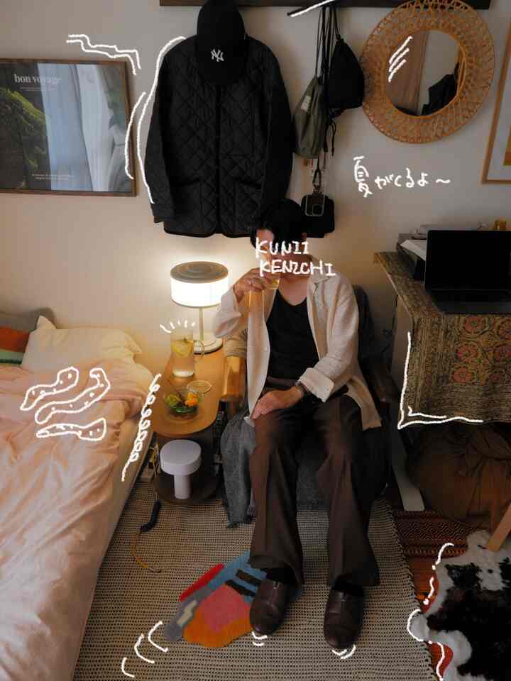 ナチュラルなブラウン調のワンルーム寝室兼リビング、ベッドとアームチェアが配置された一人暮らしの居心地の良い空間